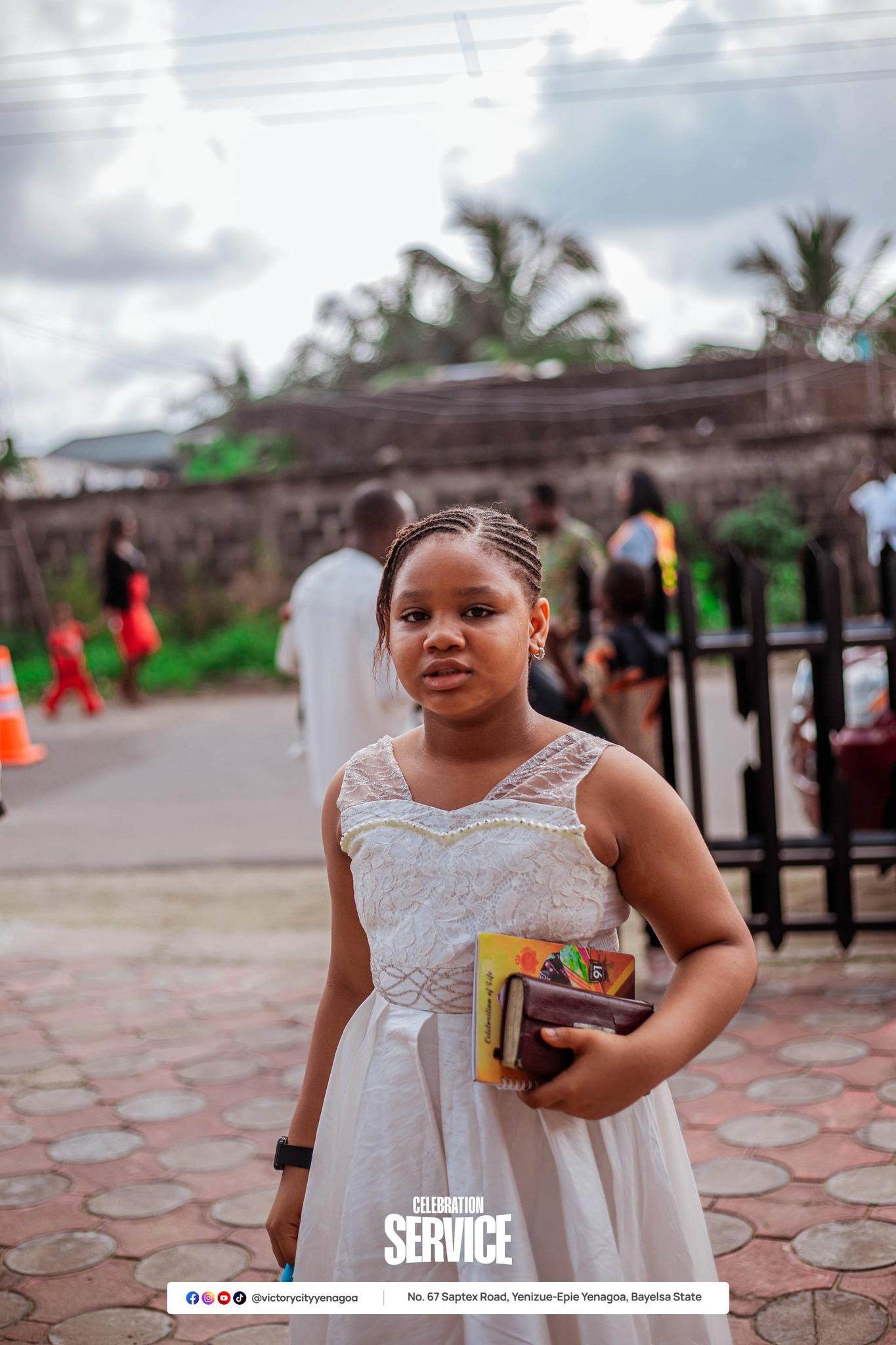 A girl in a white gown at a Victory City celebration service